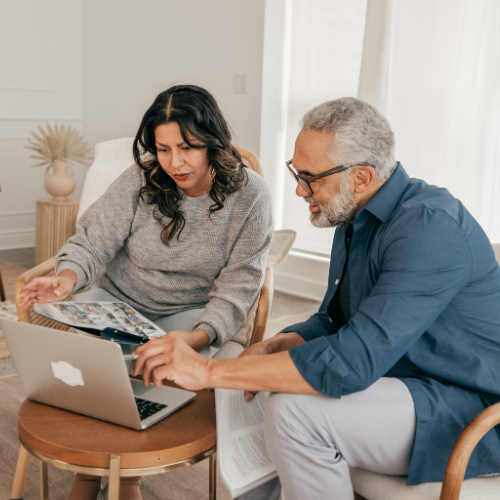Two residents engaged with a laptop in a cozy interior setting