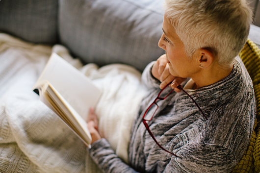 Senior woman reading a book in a cozy setting