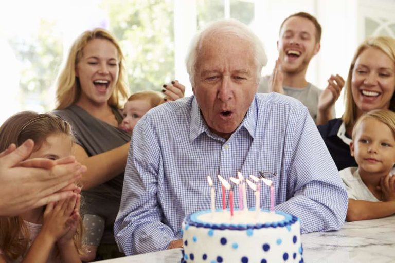 Residents celebrating a birthday with cake and candles