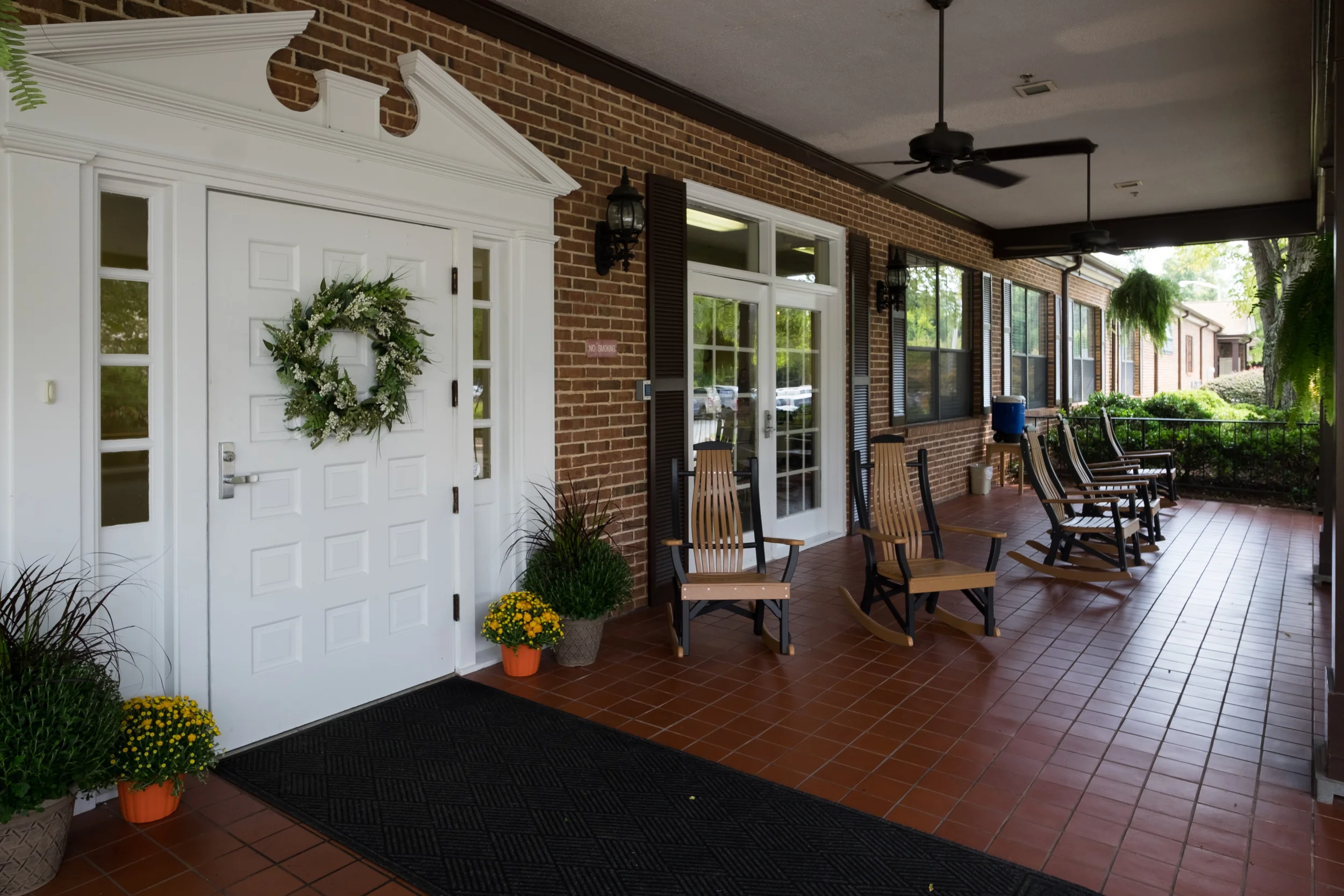 Front entrance of a senior living facility with rocking chairs