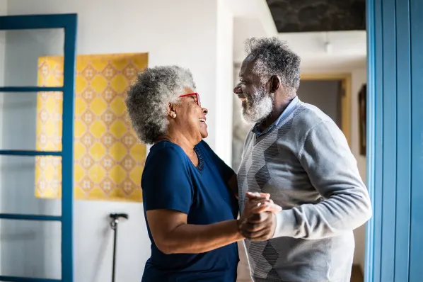 Elderly couple dancing joyfully in a facility interior