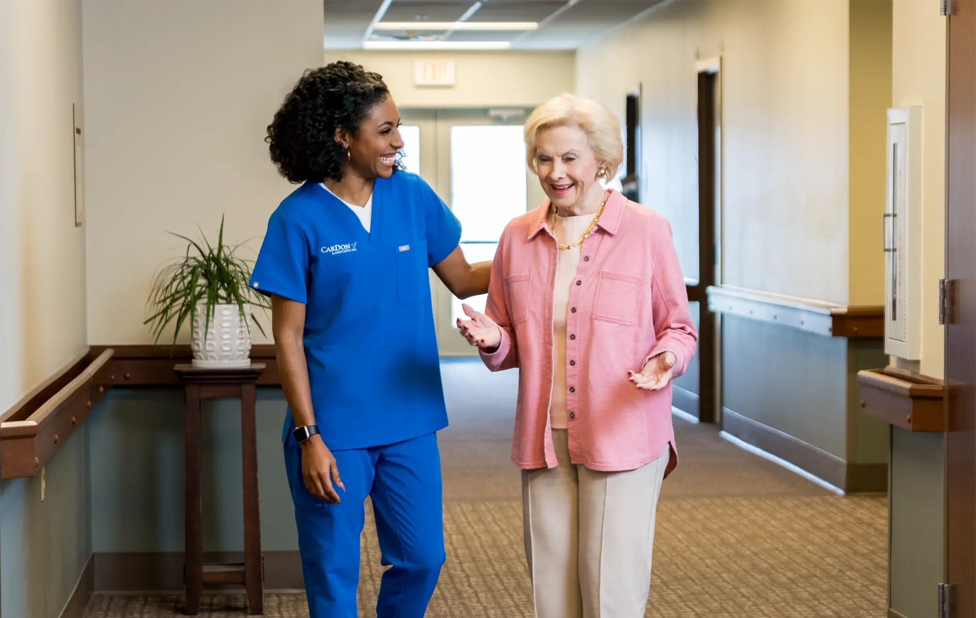 Staff assisting a resident in a hallway