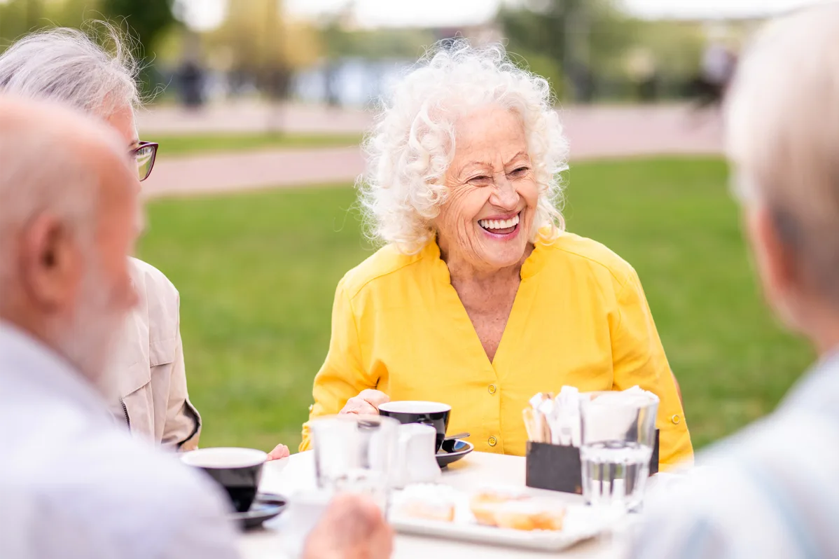 Residents enjoying coffee outdoors in a sunny setting