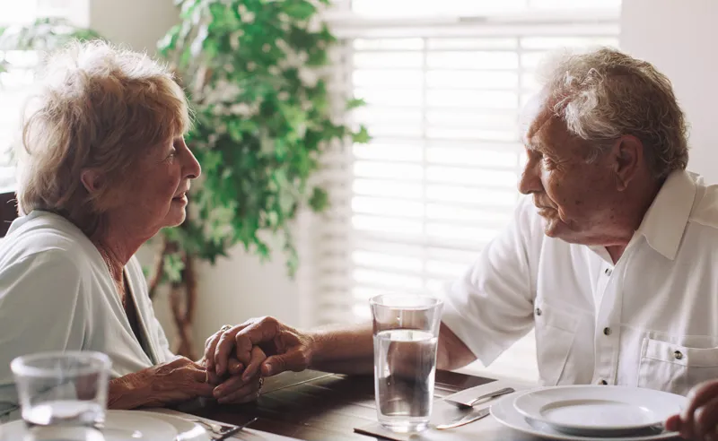 Two residents enjoying a conversation at a dining table