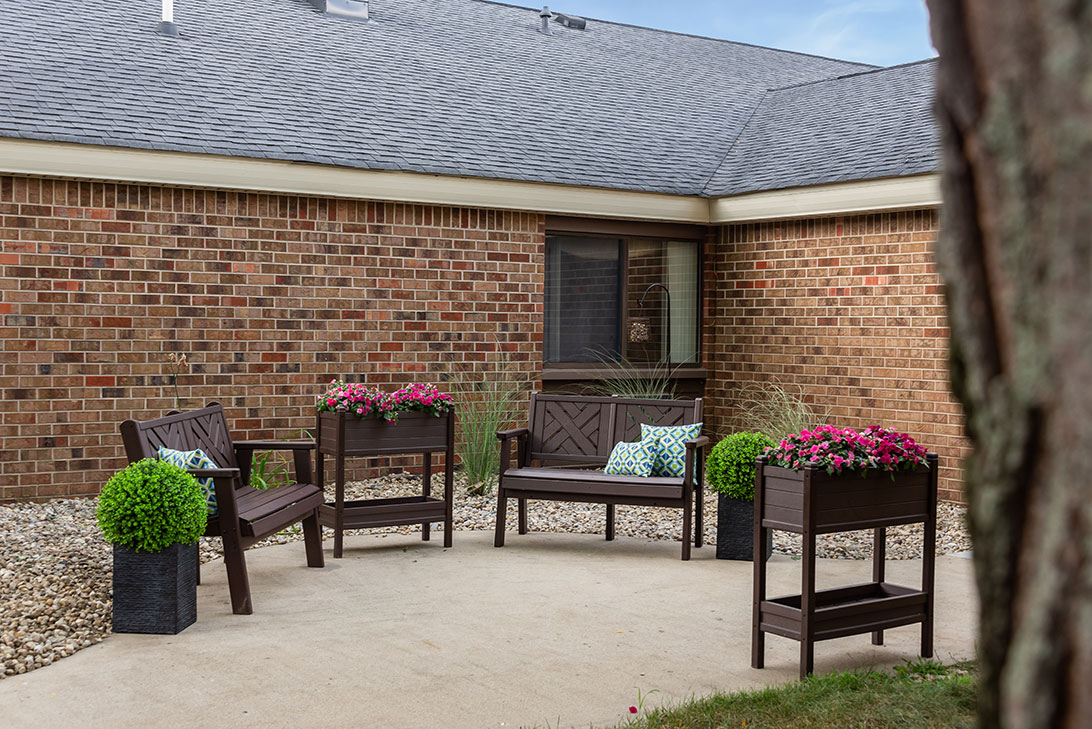 Outdoor seating area with flowers and greenery