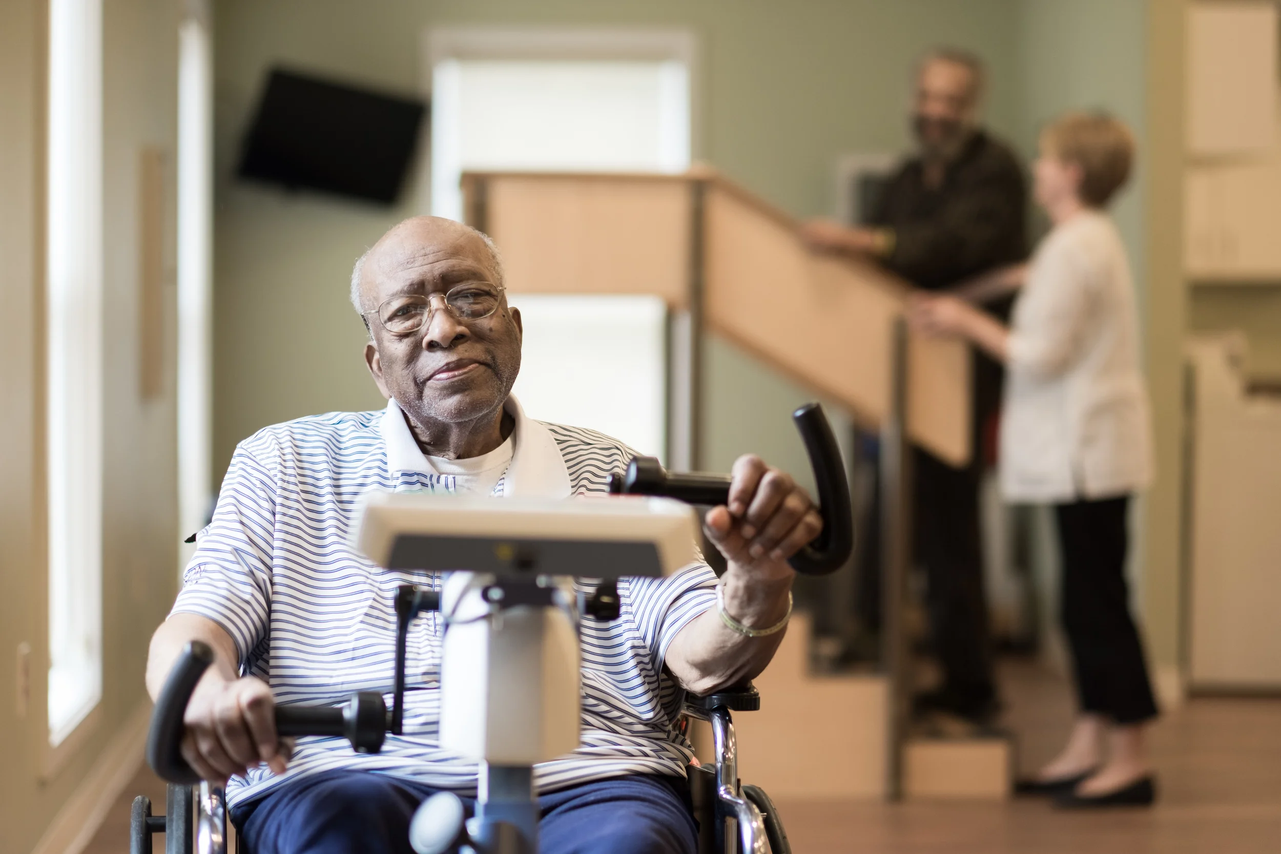 Senior resident engaging with therapy equipment in an activity room