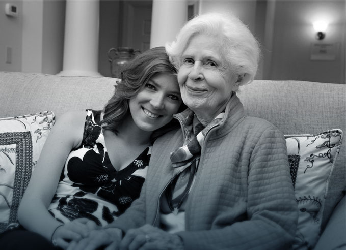 A resident and staff member sitting together on a couch