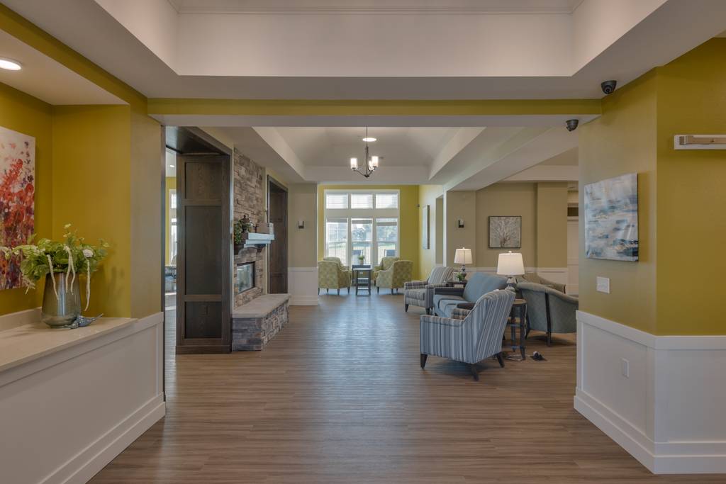 Common area with seating and fireplace in assisted living facility