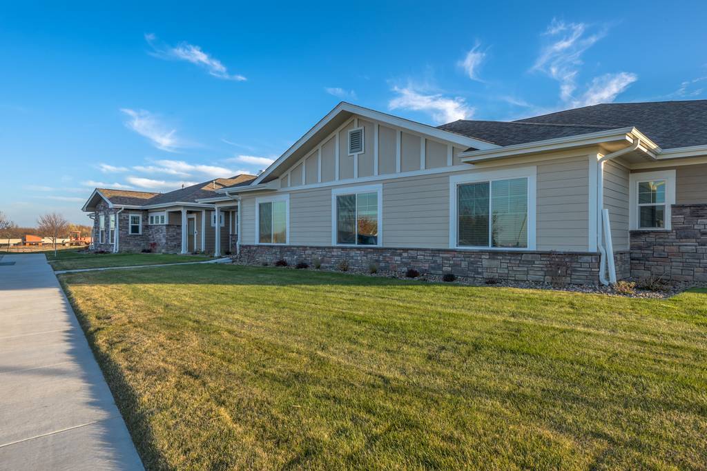 Exterior view of a senior living facility with green lawn