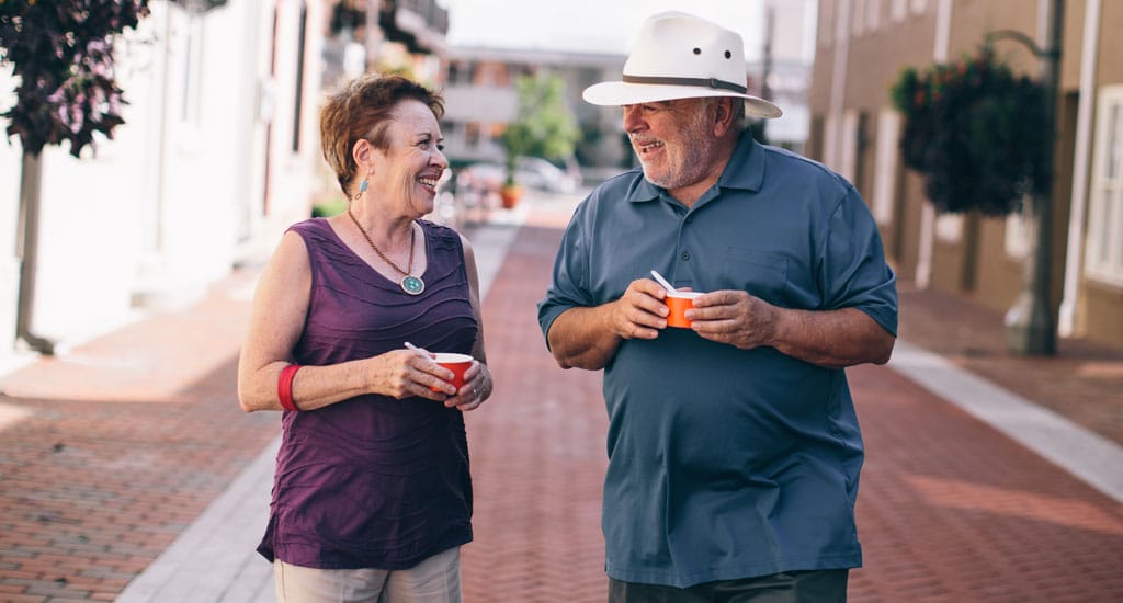 Two residents enjoying ice cream on a sunny path
