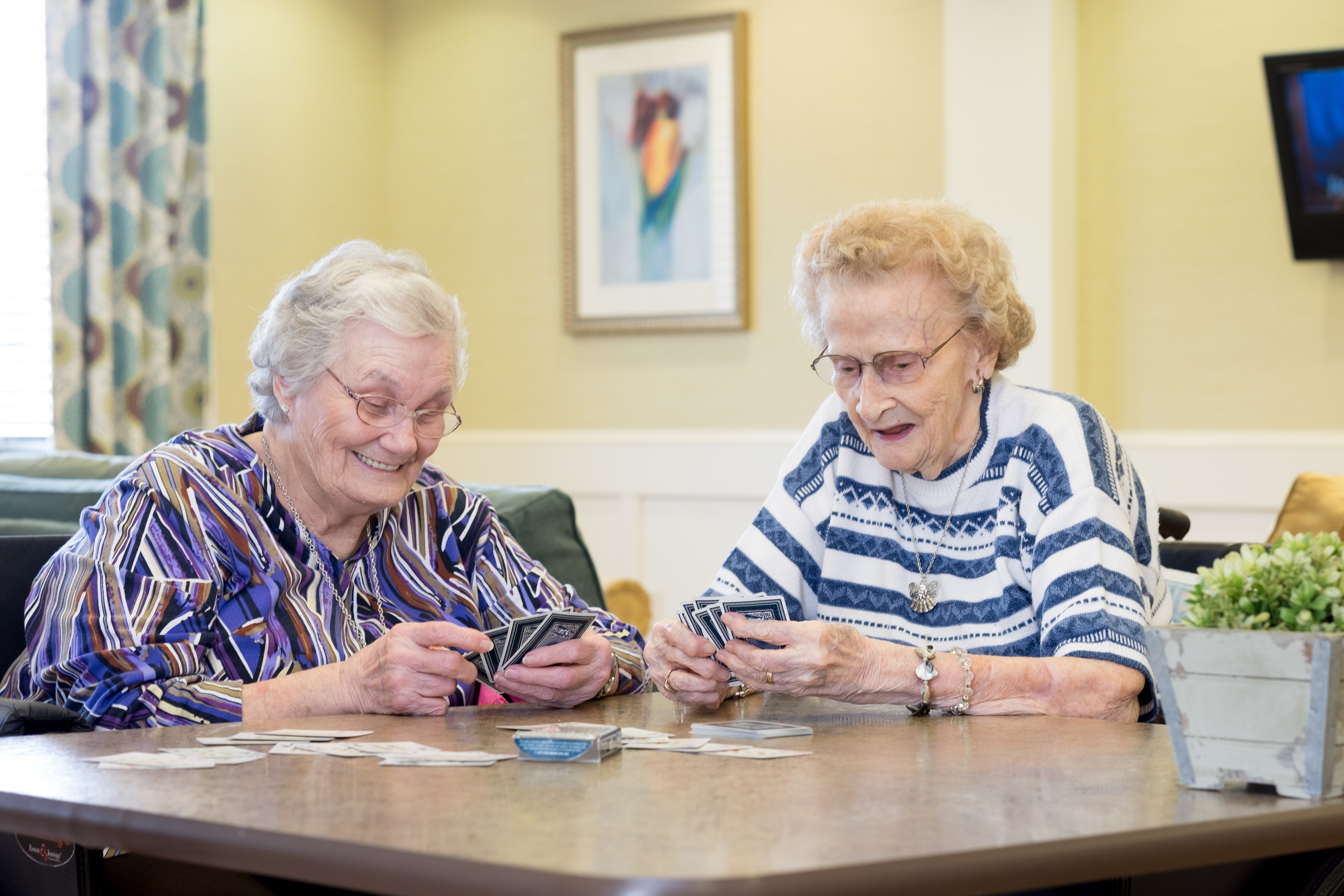Two residents playing cards in a common area