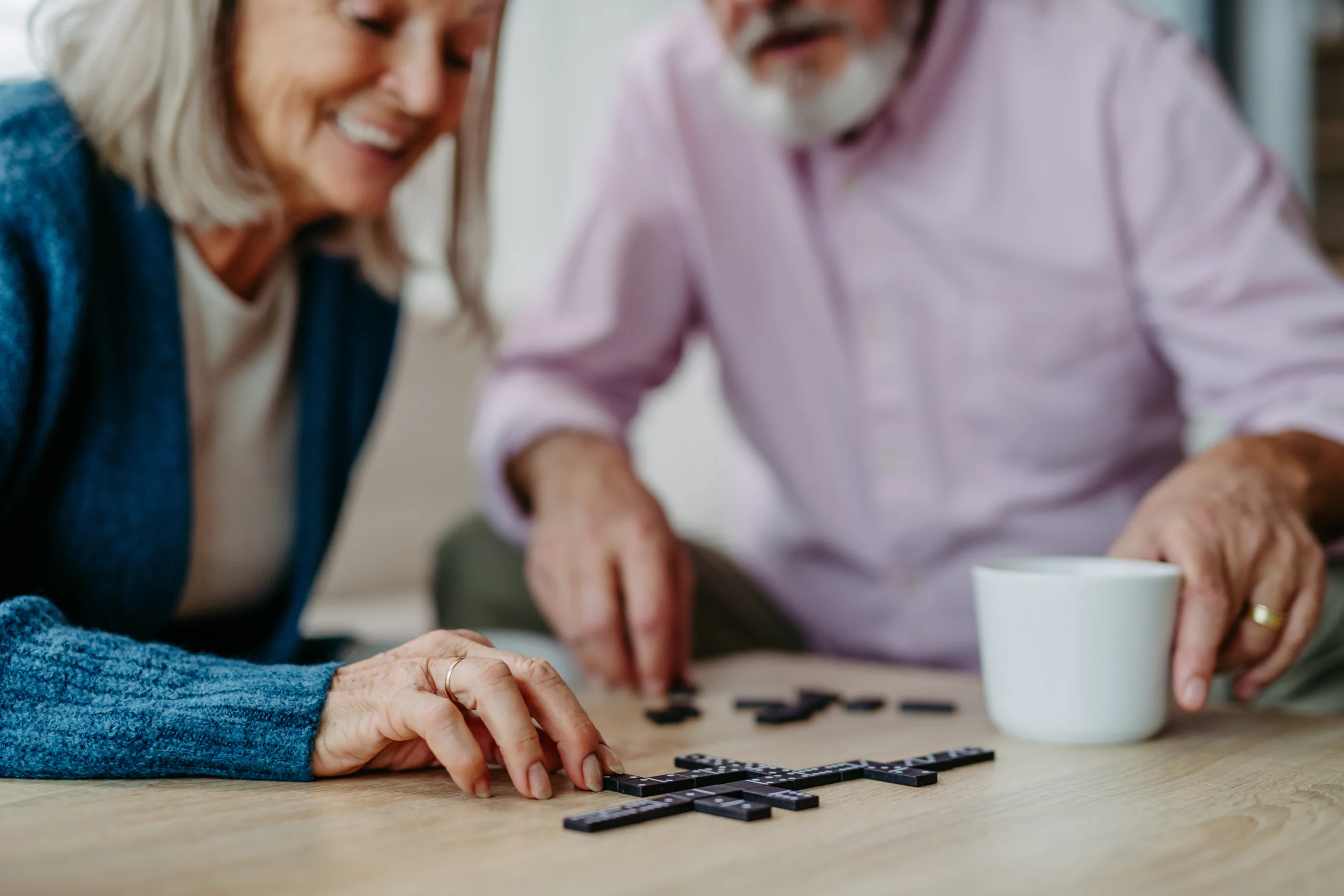 Two seniors enjoying a game of dominoes.