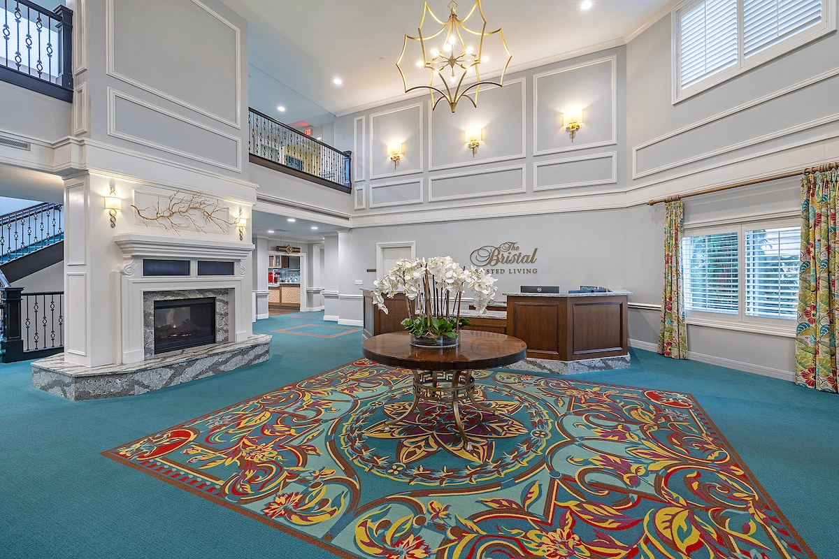 Bright lobby area with decorative carpet and fireplace