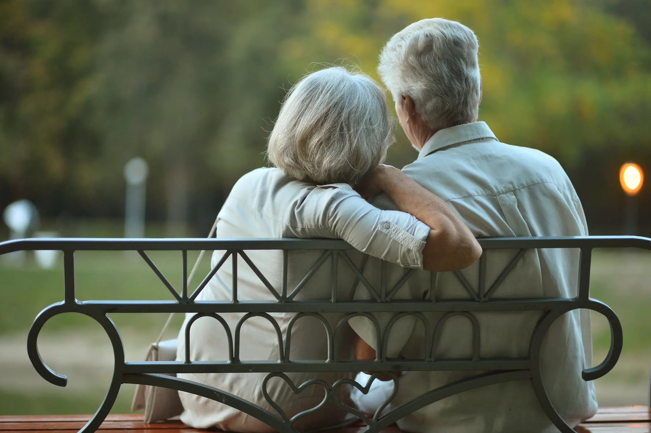 Elderly couple sitting on a bench in a park