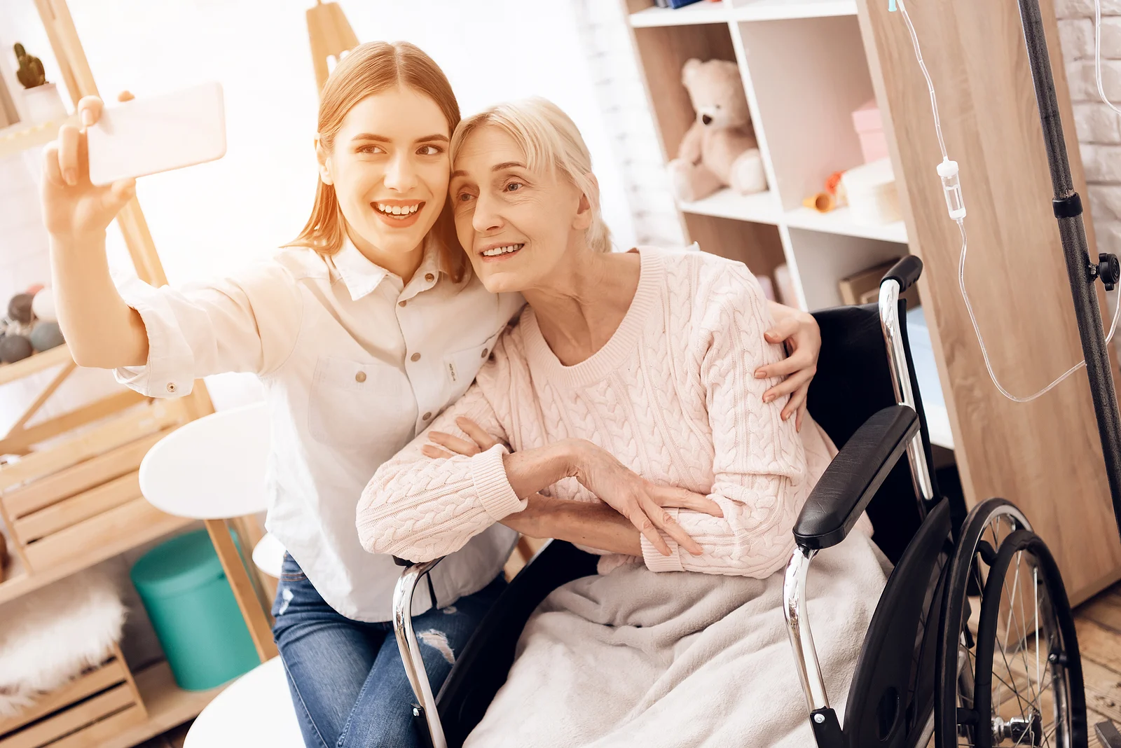 Resident and staff member smiling for a selfie in a cozy setting