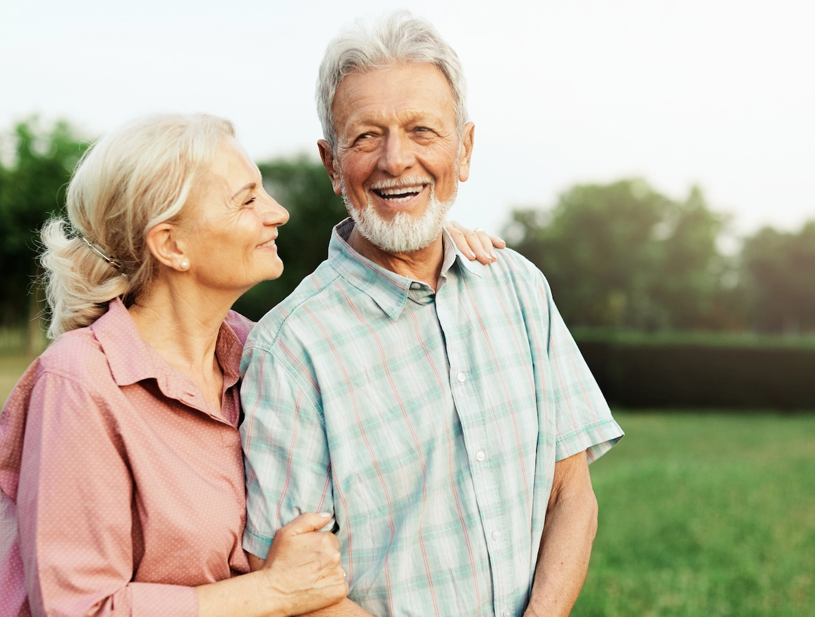 A senior couple smiling together in a park