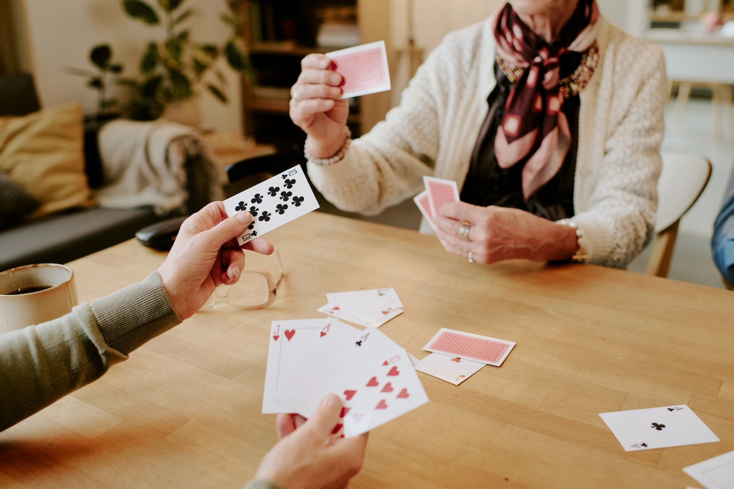 Residents playing cards around a wooden table