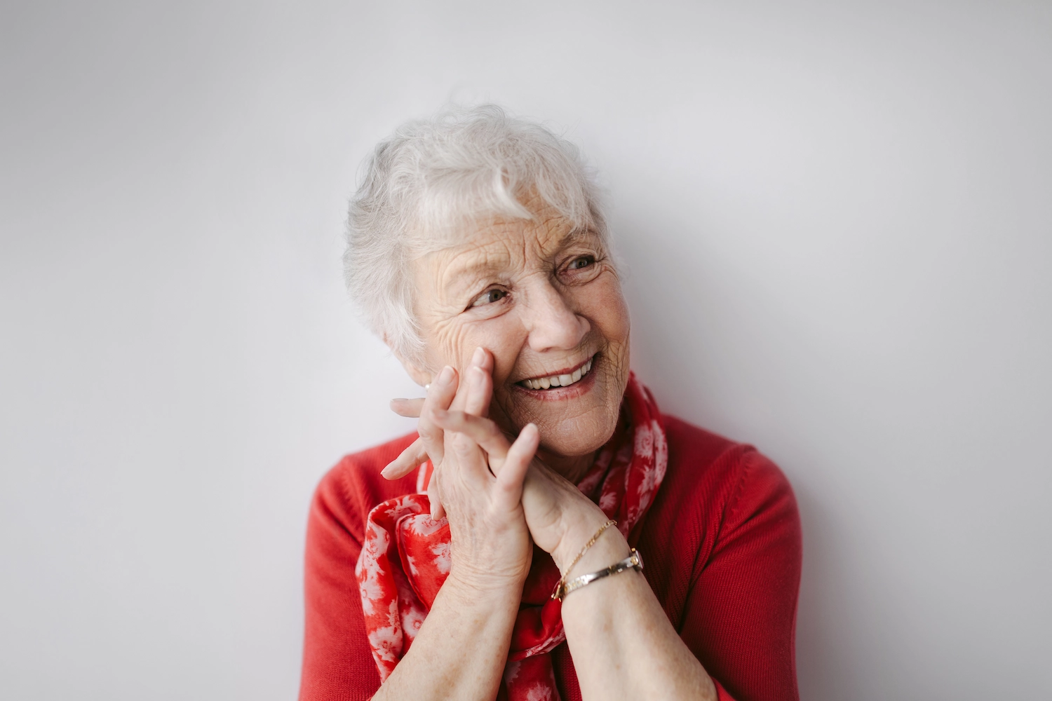 Elderly woman smiling in a red scarf