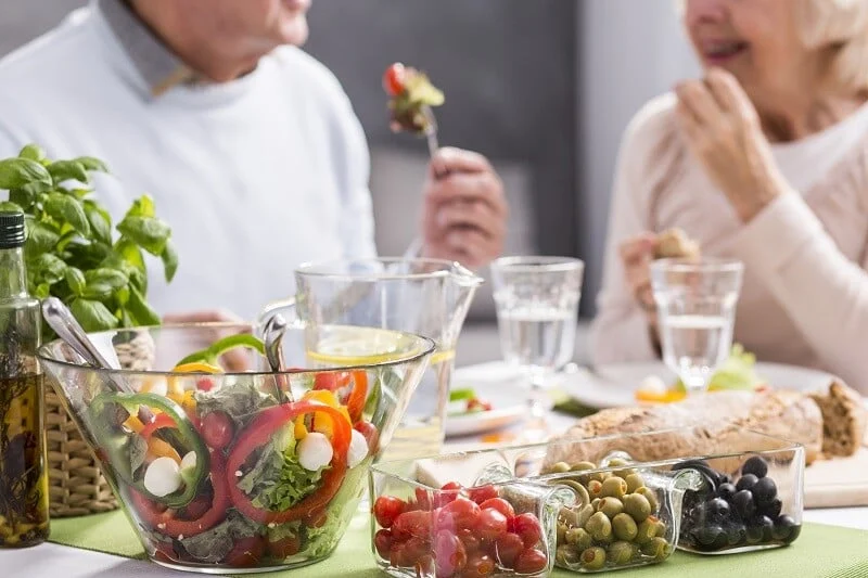 Residents enjoying a meal with fresh salad
