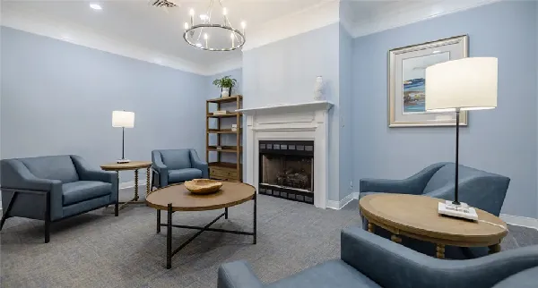 Cozy lounge area with blue chairs and fireplace