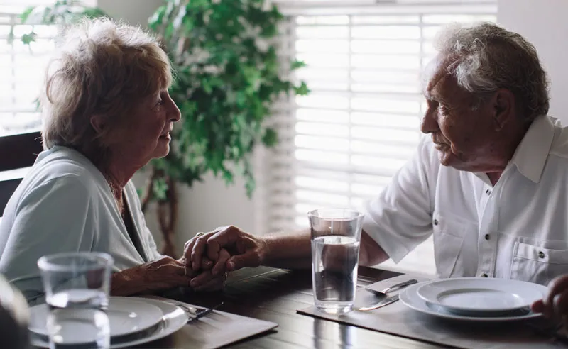 Two residents enjoying a conversation at a dining table