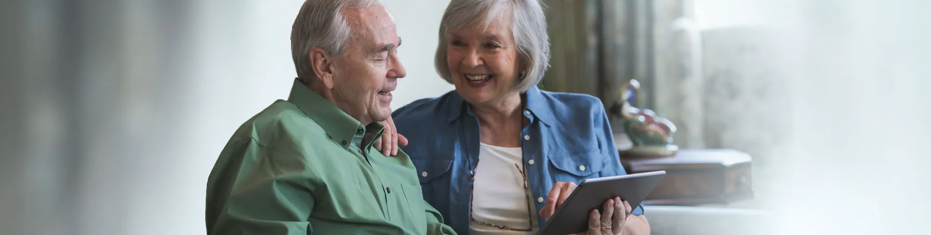 Two seniors enjoying time together with a tablet
