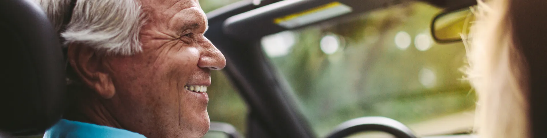 Senior man smiling in a car interior