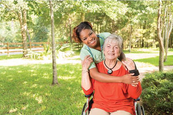 Happy nurse and resident enjoying outdoor time