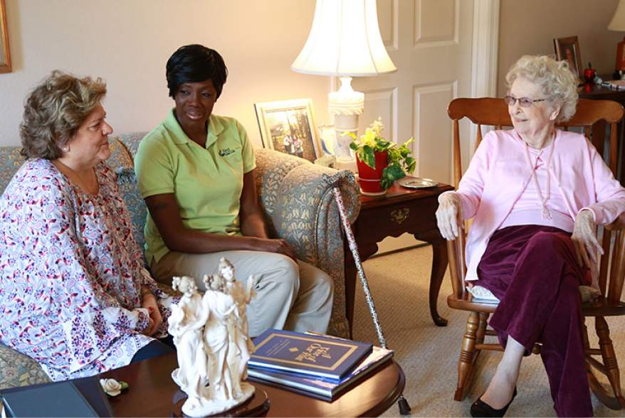 Residents and staff engaged in conversation in a cozy living area.