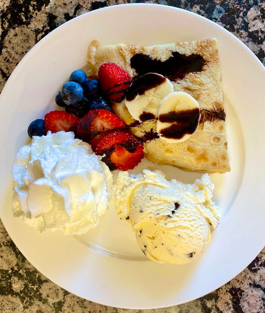 Dessert plate with crepes, ice cream, and fruit