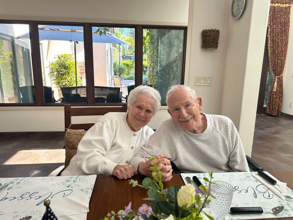 Smiling elderly couple in a warm interior setting.