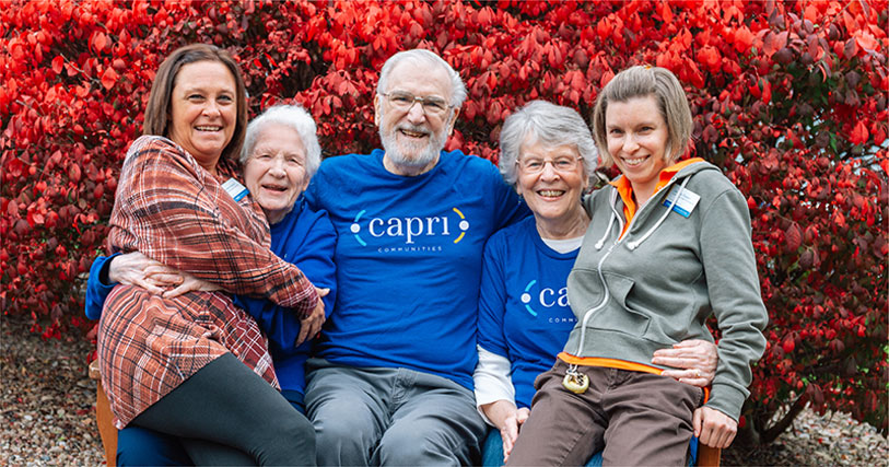 Group of smiling residents and staff outdoors