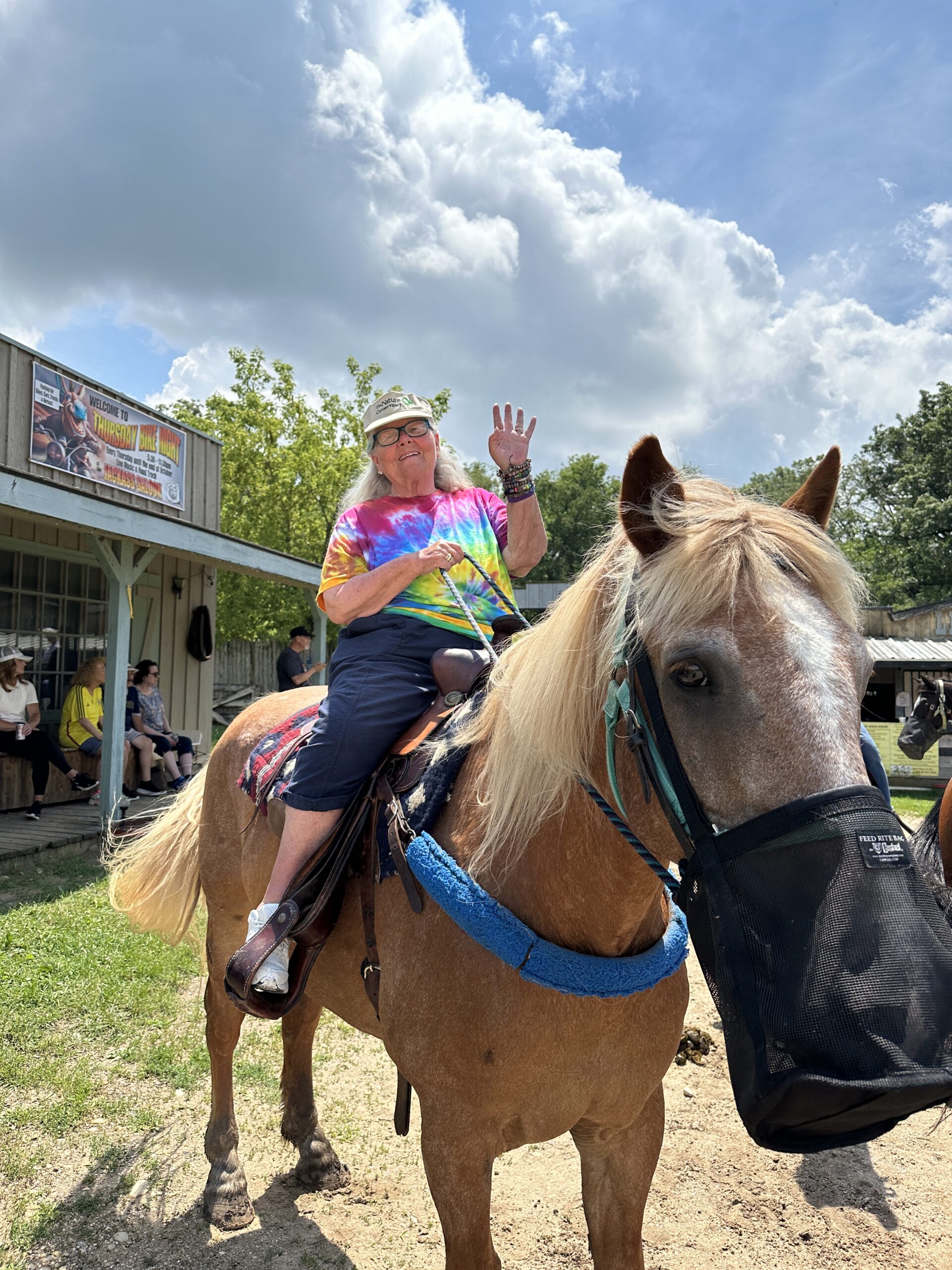 Senior woman joyfully riding a horse outdoors