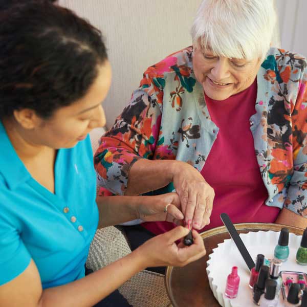 Resident receiving a manicure from staff member.