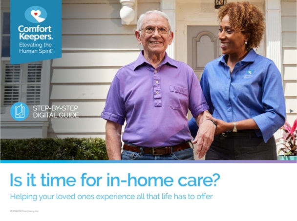 A caregiver assisting a senior man outdoors.