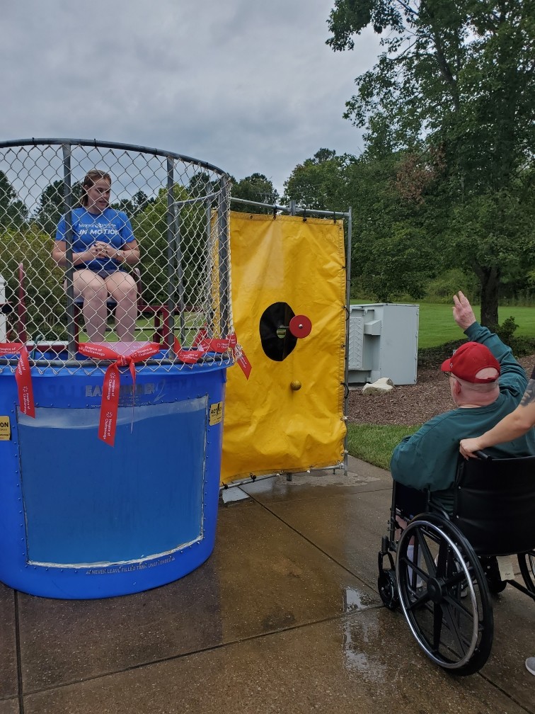 Resident in wheelchair interacting during a dunk tank event.