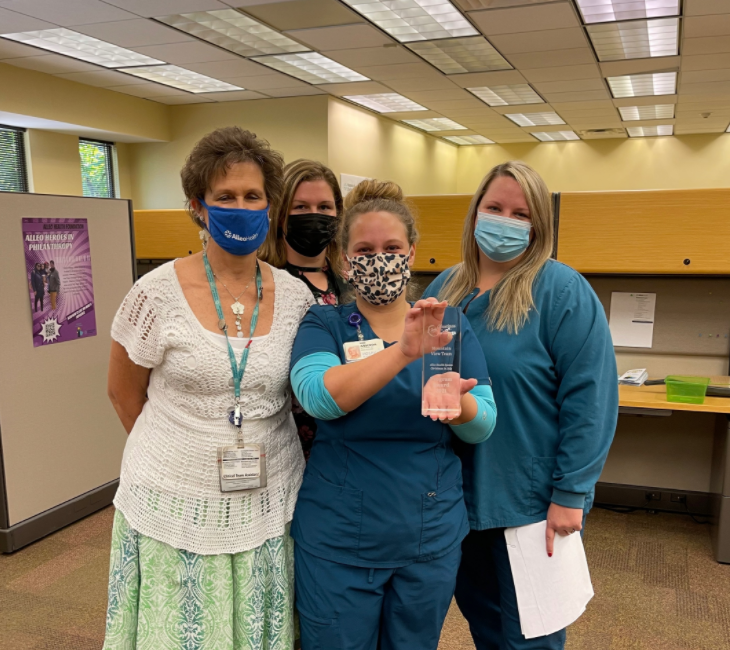 Staff members celebrating with an award.