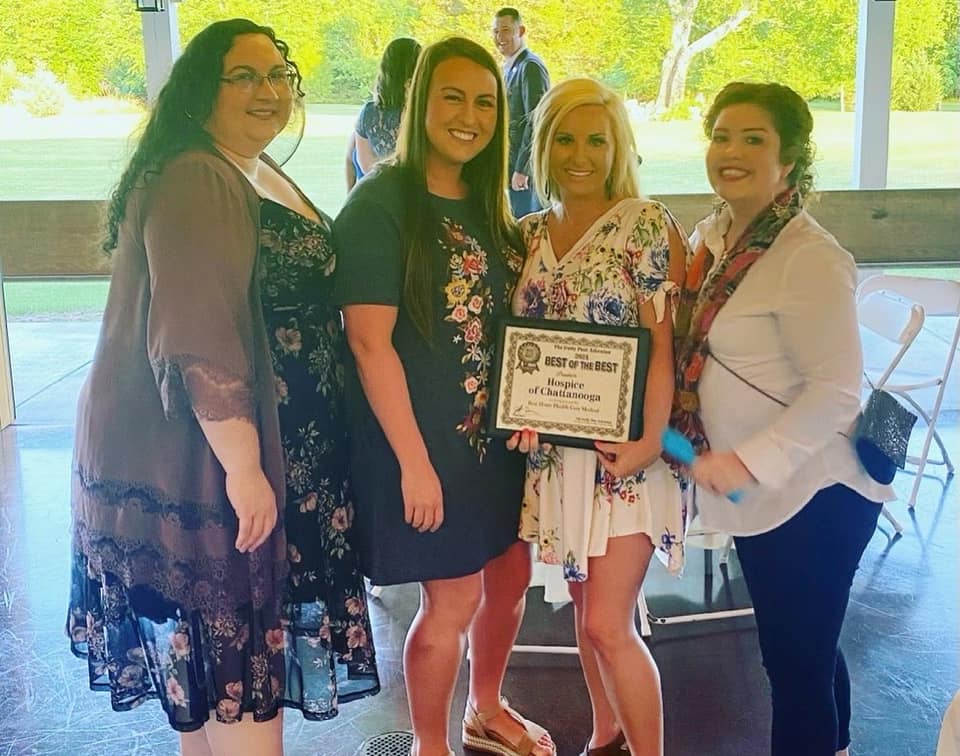 A group of four women holding an award