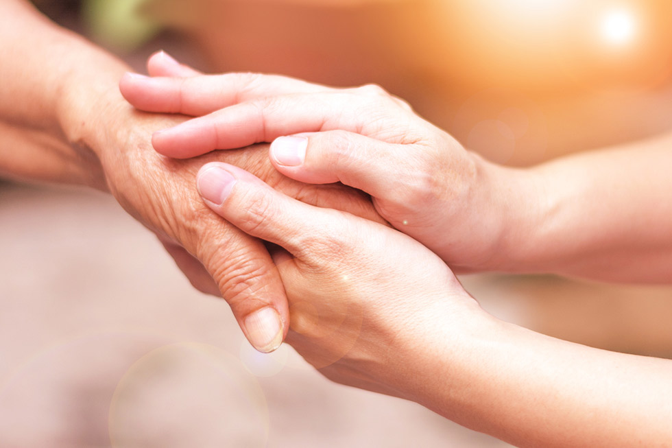 Two hands holding each other in a supportive gesture.