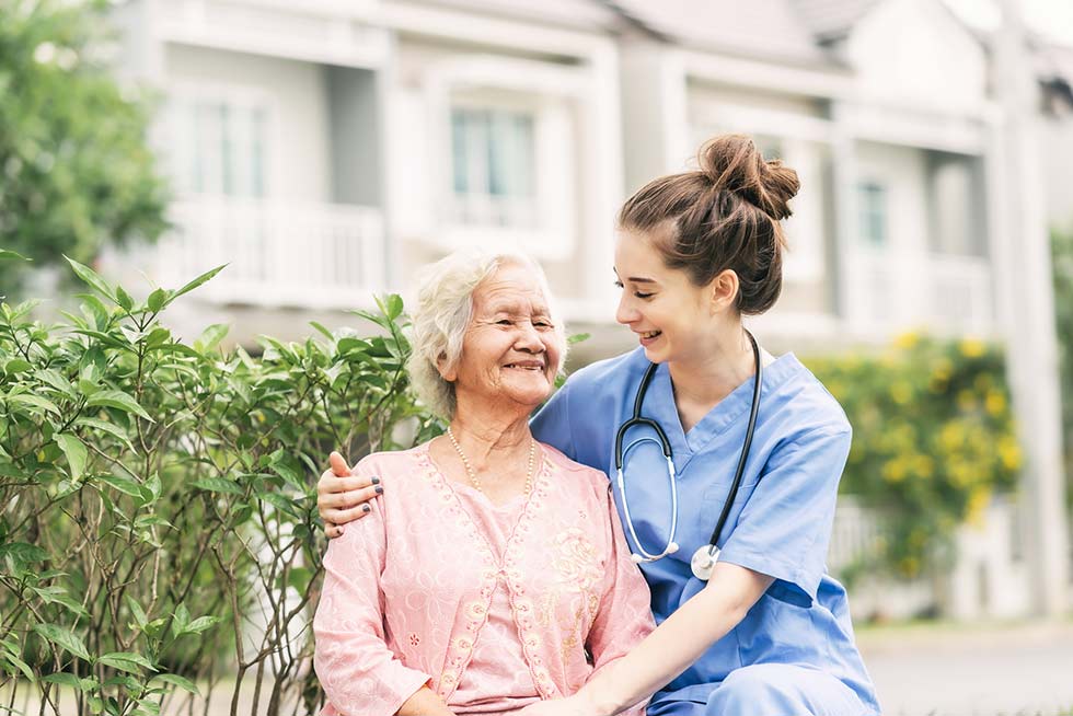 Nurse interacting with a senior woman outdoors