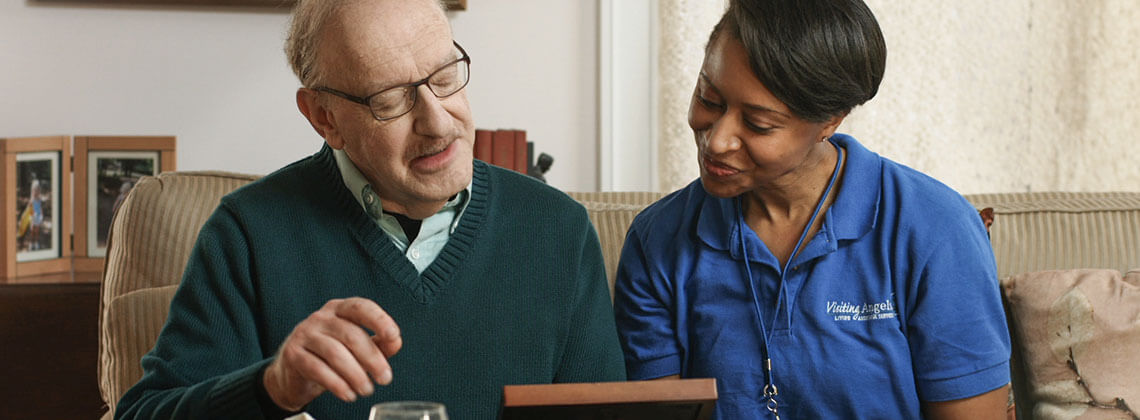 A caregiver showing a photo to a senior resident.
