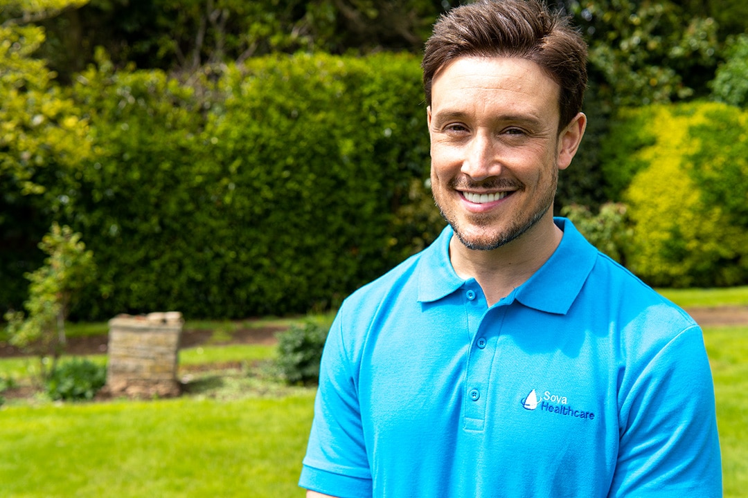 Smiling staff member in a garden setting
