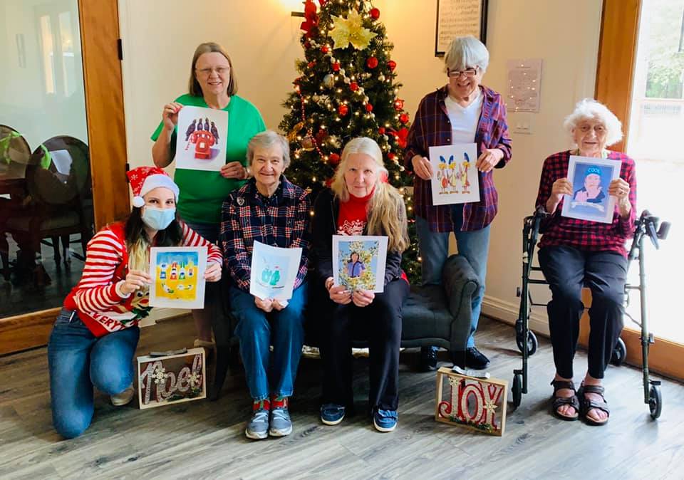 Residents holding artwork during a holiday celebration.