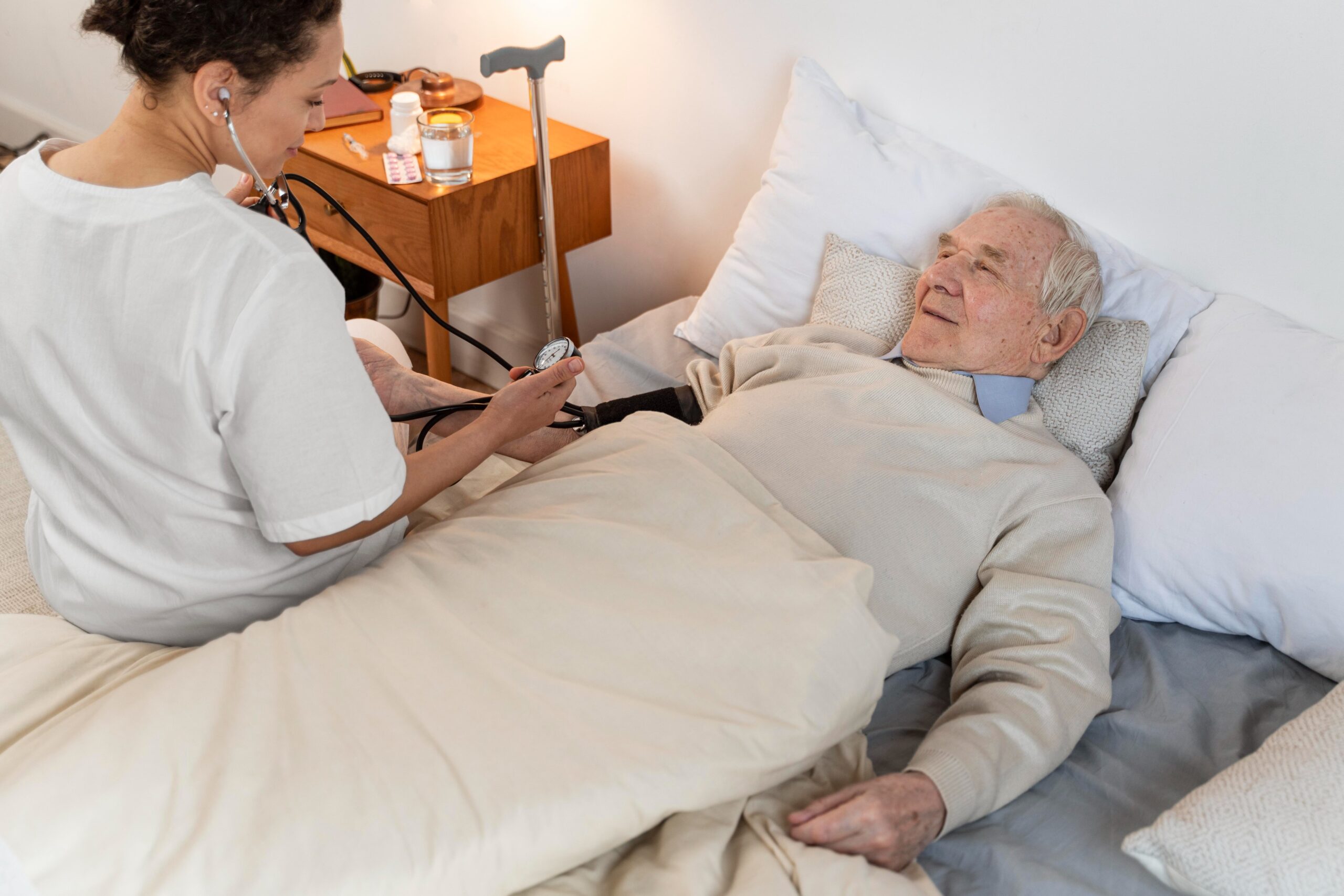 Nurse taking care of elderly resident in a bedroom