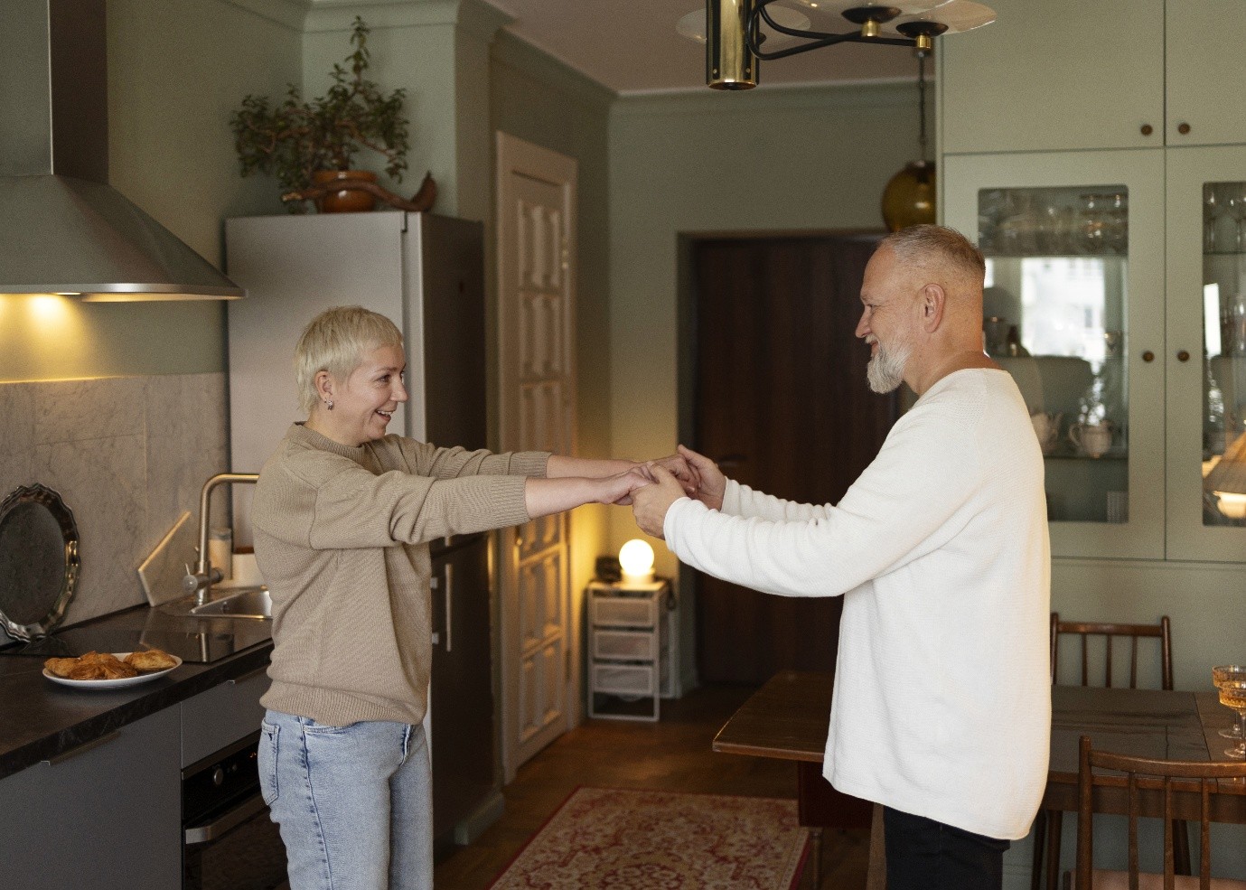 Happy interaction between two people in a cozy kitchen.