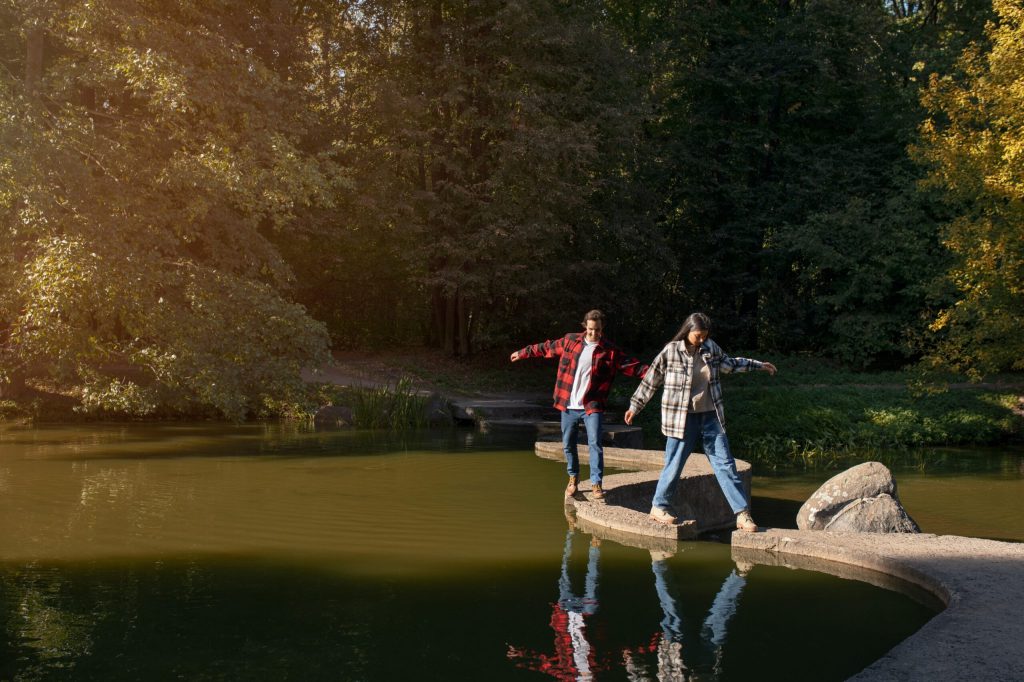 Two individuals walking on a stone path over water.