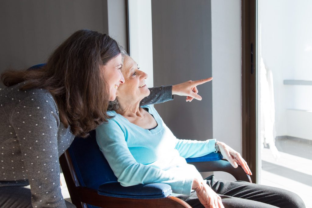 A caregiver and resident enjoying a moment together indoors.