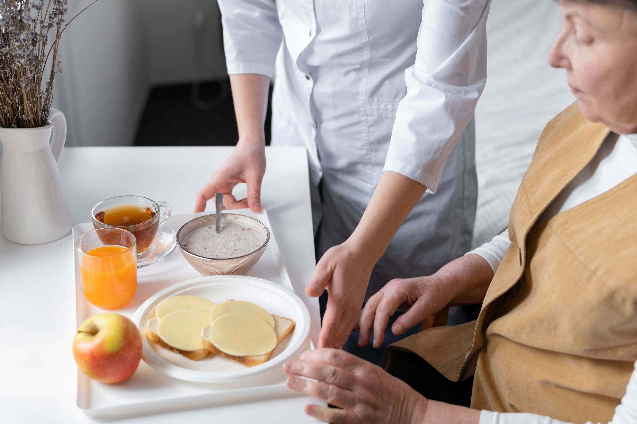 Caregiver serving food to a senior resident