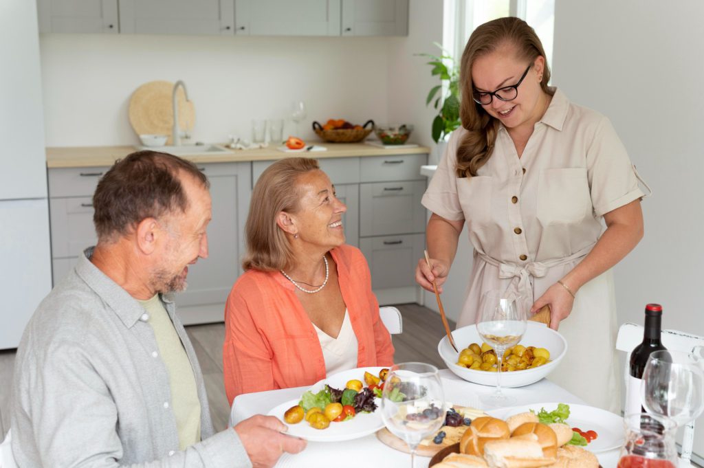 Staff serving food to happy residents in a dining area.