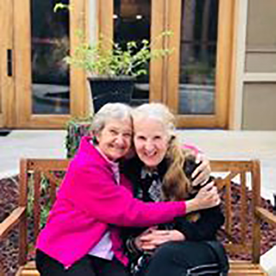 Two residents enjoying time together outdoors.